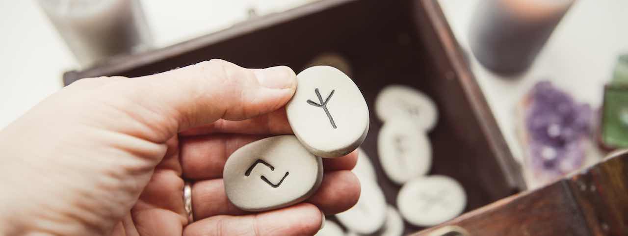 Zwei Runensteine in einer Hand.